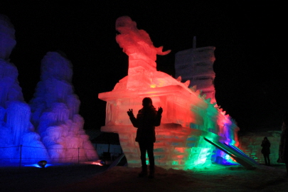 얼음분수축제의 야경 조각상에서 사진을 찍고있는 아이의 모습 